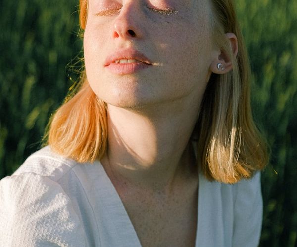 Close-up of a person's serene face with eyes closed in meditation.