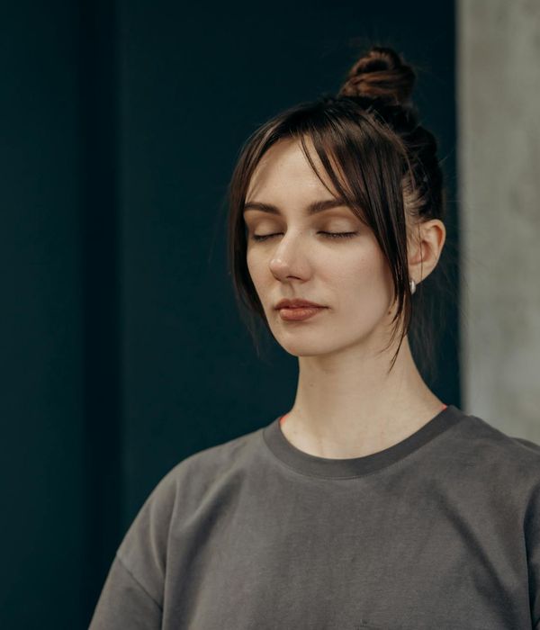Woman in a flowing yoga pose in a calm, minimalist room.